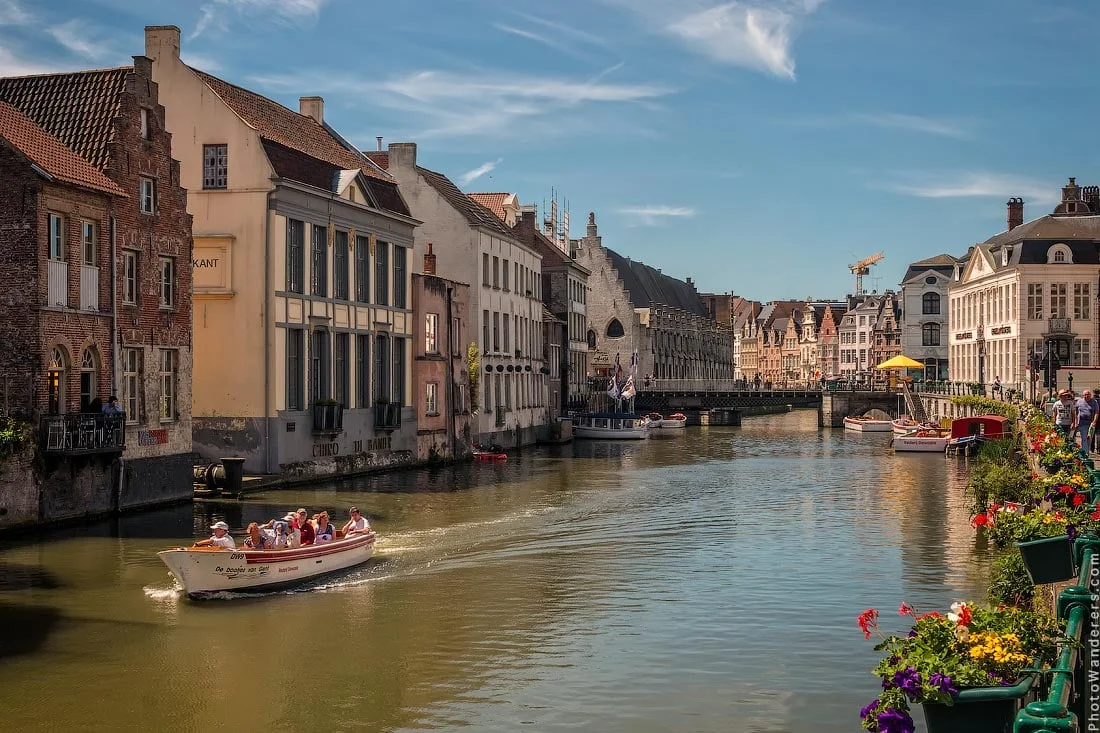 Ghent in the morning — guild houses along the Leie, a boatful of strangers drifting past.