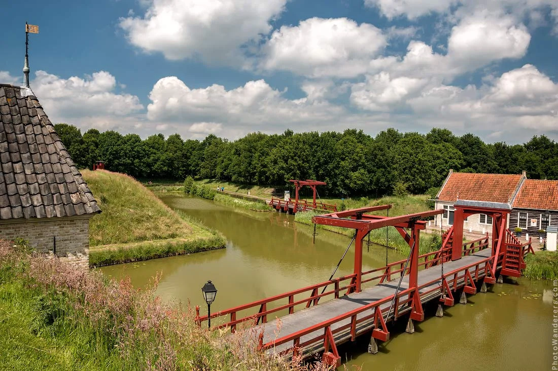 Bourtange from the ground: a red drawbridge, a green moat, and no hint of the star we'd come to see