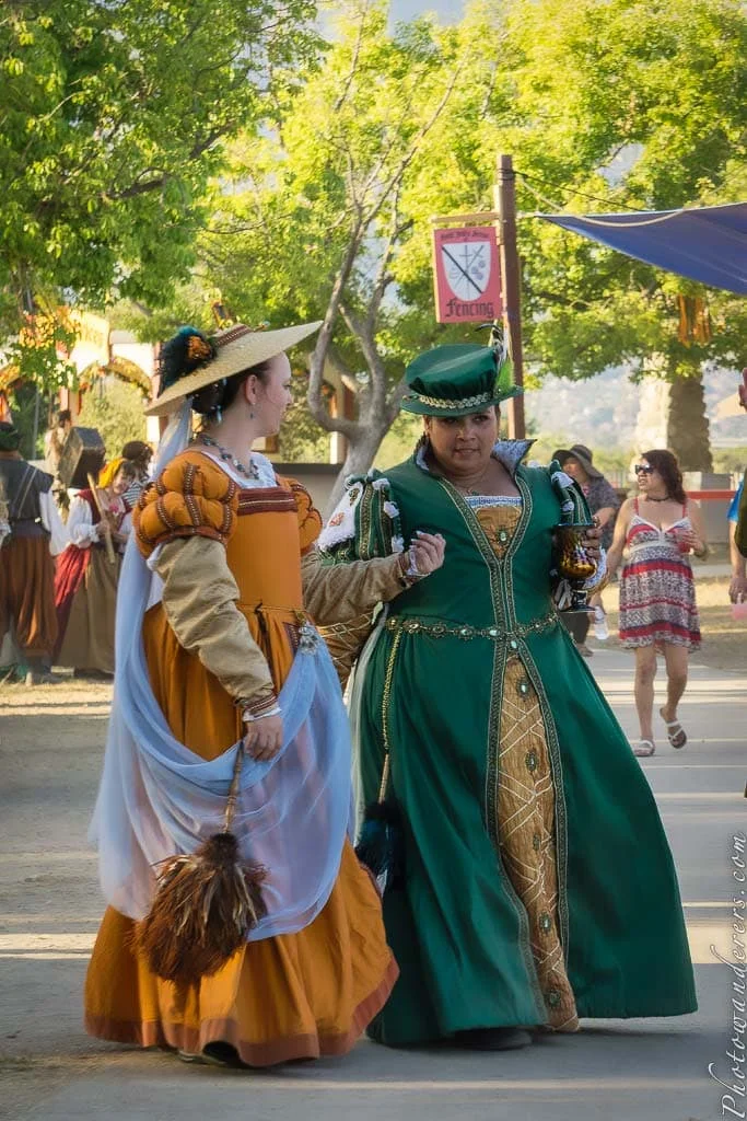 Ladies of the Queen's Court in amber and deep green.