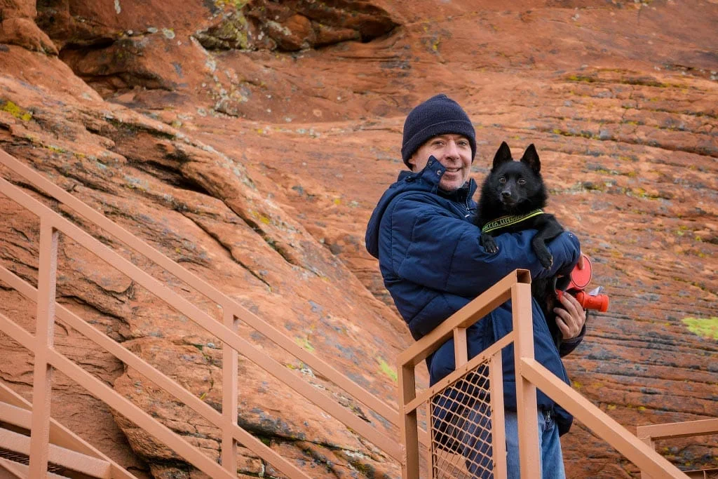 Alex carrying Jack up the metal staircase at Atlatl Rock