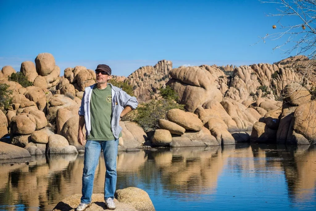 Alex standing on a boulder at the water's edge
