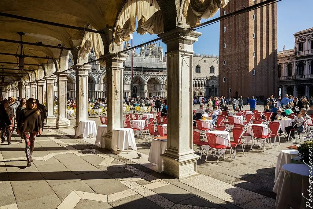 Small round café tables scattered across Piazza San Marco, Venice